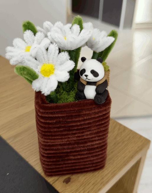 panda siedząca w stokrotkach z wyciorków